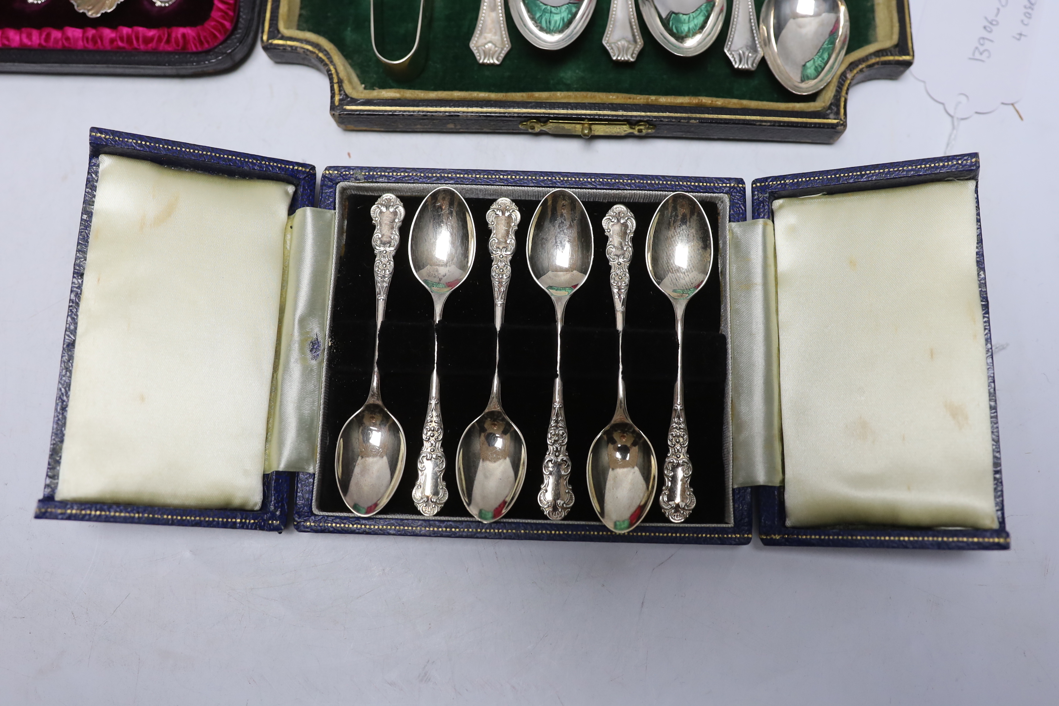 Four assorted sets of six coffee or tea spoons, including two with sugar tongs.